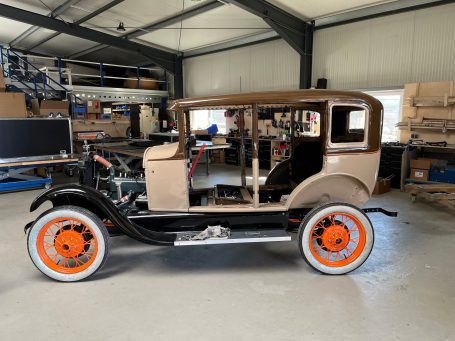 Hochzeit von Karosse und Rahmen Ford Model A Hochzeit in der Werkstatt. Karosse und Fahrgestell werden zusammengebaut
